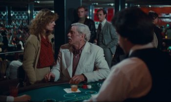 Movie still from “Atlantic City” (1980), directed by Louis Malle – A man sitting at a table in front of a woman; Medium shot, Over the shoulder angle