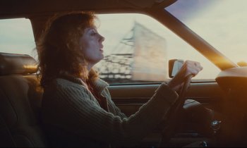 Movie still from “Atlantic City” (1980), directed by Louis Malle – A woman sitting in the driver's seat of a car; Medium shot, Low angle