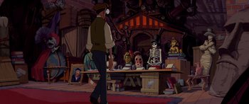 Movie still from “Atlantis: The Lost Empire” (2001), directed by Gary Trousdale – A man is walking in front of a table of skeletons; Wide shot, Over the shoulder angle
