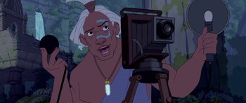Movie still from “Atlantis: The Lost Empire” (2001), directed by Gary Trousdale – An old man is taking a picture with a camera; Medium shot, Low angle