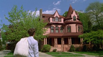 Movie still from “Sophie's Choice” (1982), directed by Alan J. Pakula – A man is standing in front of a large pink house; Wide shot, Low angle