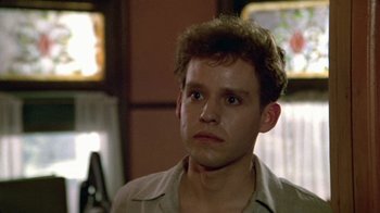 Movie still from “Sophie's Choice” (1982), directed by Alan J. Pakula – A young man with a beard is looking at the camera; Close Up shot, Low angle