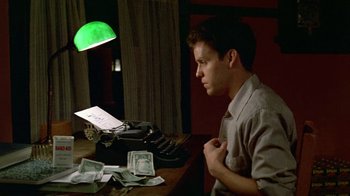 Movie still from “Sophie's Choice” (1982), directed by Alan J. Pakula – A man sitting in front of an old fashioned typewriter; Medium shot, High angle