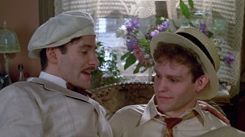 Movie still from “Sophie's Choice” (1982), directed by Alan J. Pakula – A couple of men sitting next to each other on top of a couch; Close Up shot, Over the shoulder angle