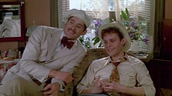 Movie still from “Sophie's Choice” (1982), directed by Alan J. Pakula – A couple of men sitting next to each other on top of a couch; Medium shot, High angle