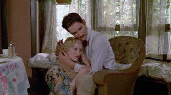 Movie still from “Sophie's Choice” (1982), directed by Alan J. Pakula – A man and a woman sitting on a couch; Medium shot, High angle