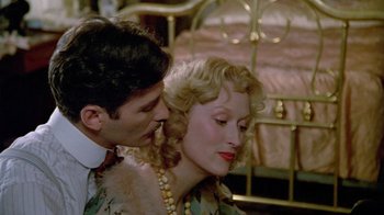 Movie still from “Sophie's Choice” (1982), directed by Alan J. Pakula – A man and a woman are kissing in front of a bed; Close Up shot, Over the shoulder angle