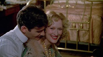 Movie still from “Sophie's Choice” (1982), directed by Alan J. Pakula – A man and a woman smiling for the camera; Close Up shot, High angle