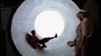 Movie still from “Sophie's Choice” (1982), directed by Alan J. Pakula – A man riding a skateboard inside of a tunnel; Wide shot, Low angle