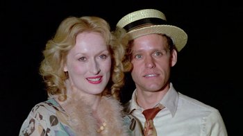 Movie still from “Sophie's Choice” (1982), directed by Alan J. Pakula – A man and a woman posing for a picture; Close Up shot, Low angle