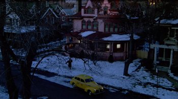 Movie still from “Sophie's Choice” (1982), directed by Alan J. Pakula – A yellow car parked on the side of the road near a house; Extreme Wide shot, High angle