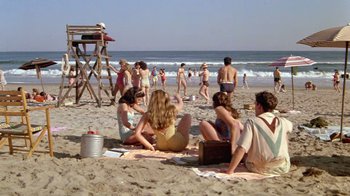 Movie still from “Sophie's Choice” (1982), directed by Alan J. Pakula – A group of people sitting on the sand at the beach; Wide shot, High angle