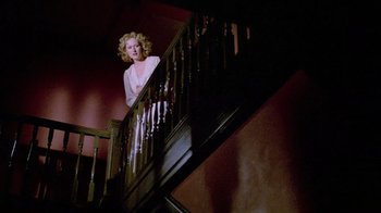 Movie still from “Sophie's Choice” (1982), directed by Alan J. Pakula – A woman standing at the bottom of a staircase; Wide shot, Low angle