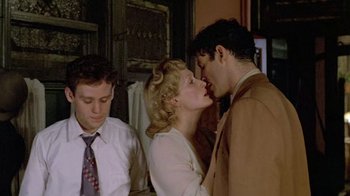 Movie still from “Sophie's Choice” (1982), directed by Alan J. Pakula – A man and a woman kissing in front of another man; Medium shot, Over the shoulder angle