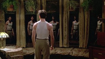 Movie still from “Sophie's Choice” (1982), directed by Alan J. Pakula – A man standing in front of three mirrors; Medium shot, Low angle