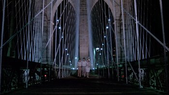 Movie still from “Sophie's Choice” (1982), directed by Alan J. Pakula – Two people are standing on a bridge at night; Extreme Wide shot, Low angle