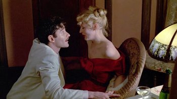 Movie still from “Sophie's Choice” (1982), directed by Alan J. Pakula – A man and a woman sitting on a couch; Medium shot, Low angle