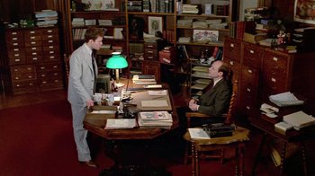 Movie still from “Sophie's Choice” (1982), directed by Alan J. Pakula – Two men are sitting at a table in a library; Wide shot, High angle