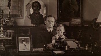 Movie still from “Sophie's Choice” (1982), directed by Alan J. Pakula – An old photo of a man and a little girl; Medium shot, High angle