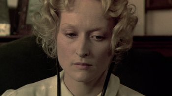 Movie still from “Sophie's Choice” (1982), directed by Alan J. Pakula – A person with curly blonde hair; Close Up shot, High angle