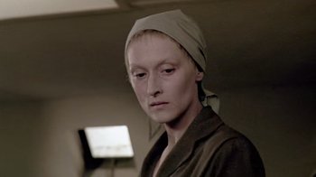 Movie still from “Sophie's Choice” (1982), directed by Alan J. Pakula – A woman wearing a head scarf is looking at the camera; Close Up shot, Over the shoulder angle