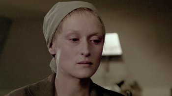 Movie still from “Sophie's Choice” (1982), directed by Alan J. Pakula – A woman wearing a head scarf and looking sad; Close Up shot, Over the shoulder angle