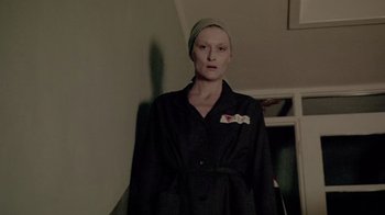 Movie still from “Sophie's Choice” (1982), directed by Alan J. Pakula – A woman wearing a black robe and a green hat; Medium shot, Low angle