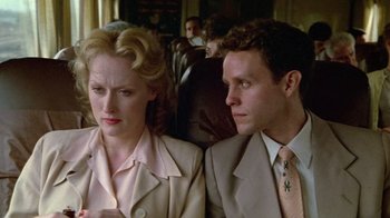 Movie still from “Sophie's Choice” (1982), directed by Alan J. Pakula – A man and a woman sitting next to each other on a train; Close Up shot, Low angle