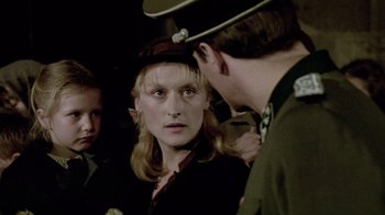 Movie still from “Sophie's Choice” (1982), directed by Alan J. Pakula – A woman in a military uniform is talking to a man in a uniform; Close Up shot, Over the shoulder angle
