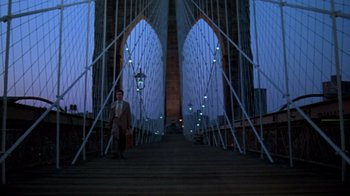 Movie still from “Sophie's Choice” (1982), directed by Alan J. Pakula – A man is standing on a bridge holding a briefcase; Wide shot, Low angle