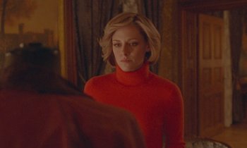 Movie still from “Spencer” (2021), directed by Pablo Larraín – A woman in a red sweater looking at a mirror; Close Up shot, Over the shoulder angle