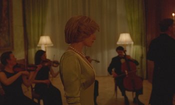 Movie still from “Spencer” (2021), directed by Pablo Larraín – A woman standing in front of a group of people; Medium shot, Low angle