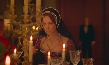 Movie still from “Spencer” (2021), directed by Pablo Larraín – A woman sitting in front of a table with lit candles; Medium shot, Over the shoulder angle