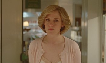 Movie still from “Spencer” (2021), directed by Pablo Larraín – A woman with blonde hair wearing a pink sweater; Close Up shot, Low angle