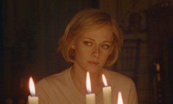 Movie still from “Spencer” (2021), directed by Pablo Larraín – A woman sitting in front of a group of lit candles; Close Up shot, Over the shoulder angle