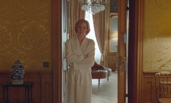 Movie still from “Spencer” (2021), directed by Pablo Larraín – A woman in a robe standing in a doorway; Medium shot, Over the shoulder angle