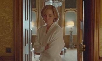 Movie still from “Spencer” (2021), directed by Pablo Larraín – A woman in a white robe standing in front of a door; Medium shot, Over the shoulder angle