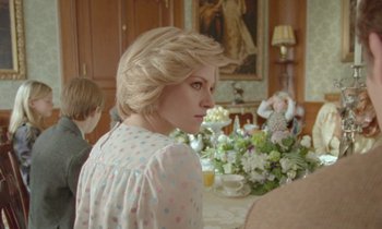 Movie still from “Spencer” (2021), directed by Pablo Larraín – A woman sitting at a dining room table with two children; Medium shot, Over the shoulder angle