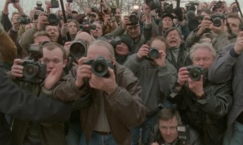Movie still from “Spencer” (2021), directed by Pablo Larraín – A group of people taking pictures with cameras; Wide shot, High angle