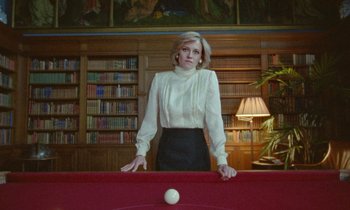 Movie still from “Spencer” (2021), directed by Pablo Larraín – A woman standing in front of a pool table in a library; Medium shot, Low angle