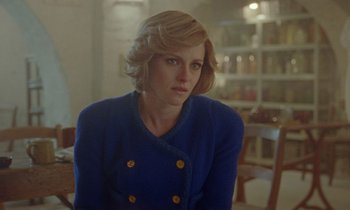 Movie still from “Spencer” (2021), directed by Pablo Larraín – A woman in a blue jacket sitting in front of a bookshelf; Close Up shot, Over the shoulder angle
