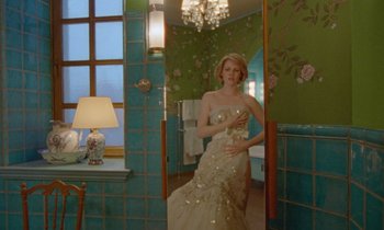 Movie still from “Spencer” (2021), directed by Pablo Larraín – A woman in a white dress in front of a bathroom mirror; Wide shot, Low angle
