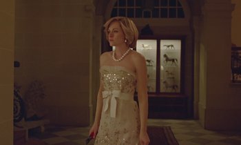 Movie still from “Spencer” (2021), directed by Pablo Larraín – A woman in a white dress holding a pink umbrella; Medium shot, Low angle