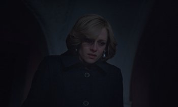 Movie still from “Spencer” (2021), directed by Pablo Larraín – A woman in a black coat standing in a dark room; Close Up shot, Low angle