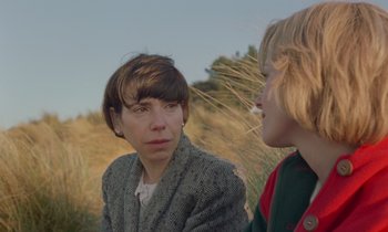 Movie still from “Spencer” (2021), directed by Pablo Larraín – A woman and a boy are sitting in a field; Close Up shot, Over the shoulder angle