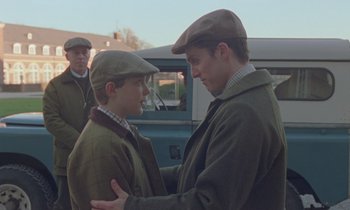 Movie still from “Spencer” (2021), directed by Pablo Larraín – Two young men are talking to each other outside; Medium shot, Over the shoulder angle