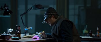 Movie still from “Spider-Man: Homecoming” (2017), directed by Jon Watts – A man wearing a welding helmet looking down at a piece of paper; Medium shot, Low angle