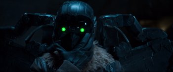 Movie still from “Spider-Man: Homecoming” (2017), directed by Jon Watts – A person wearing a helmet with green eyes; Close Up shot, Over the shoulder angle