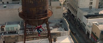 Movie still from “Spider-Man: Homecoming” (2017), directed by Jon Watts – A spider - man climbing up the side of an old water tower; Extreme Wide shot, Overhead angle