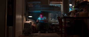 Movie still from “Spider-Man: Homecoming” (2017), directed by Jon Watts – A man sitting on a bed wearing a spider man mask; Wide shot, Overhead angle